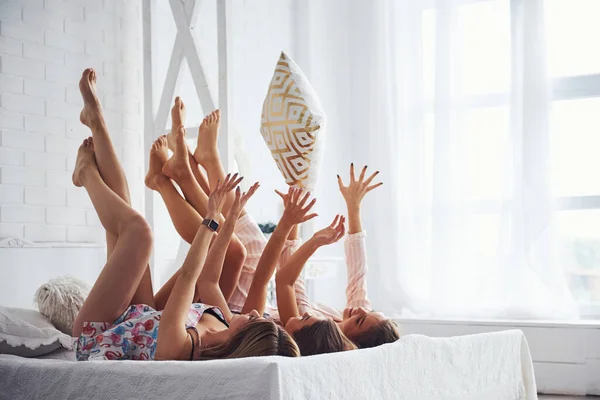 玩枕头的游戏在睡房的睡衣派对上玩得开心的女性朋友 — 图库照片
