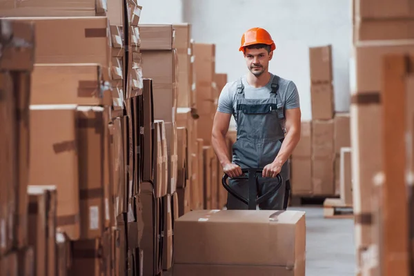 Jovem Trabalhador Masculino Uniforme Está Armazém Com Caminhão Paletes — Fotografia de Stock