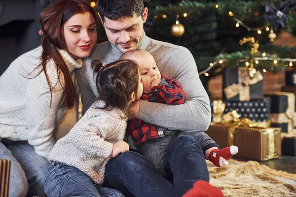 美丽的高加索夫妇带着他们的小儿子和女儿在屋里庆祝圣诞节 — 图库照片