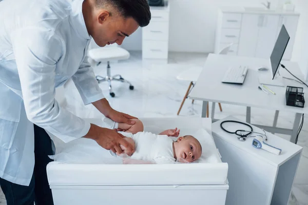 Νεαρός Παιδίατρος Είναι Μωρό Στην Κλινική Την Ημέρα — Φωτογραφία Αρχείου