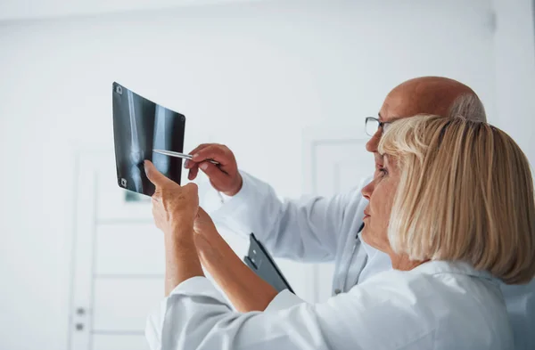Médicos Senior Uniforme Blanco Examinan Radiografía Piernas Humanas — Foto de Stock
