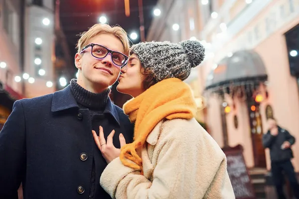 Fiatal Lány Áll Karácsonyi Díszített Utcán Megcsókolja Barátját — Stock Fotó
