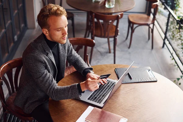 Resmi Kıyafetli Zarif Bir Genç Elinde Laptopu Kredi Kartıyla Kafede — Stok fotoğraf