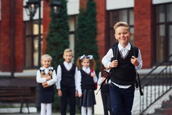 Groupe Enfants Uniforme Scolaire Posant Caméra Extérieur Ensemble Près Bâtiment — Photo