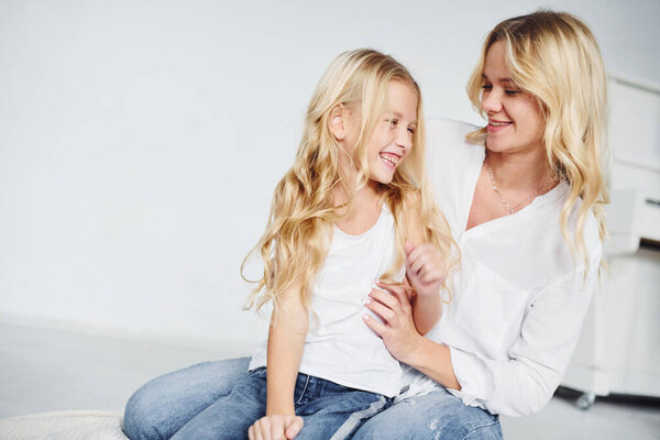 Closeness of the people. Mother with her daughter together in the studio with white background.
