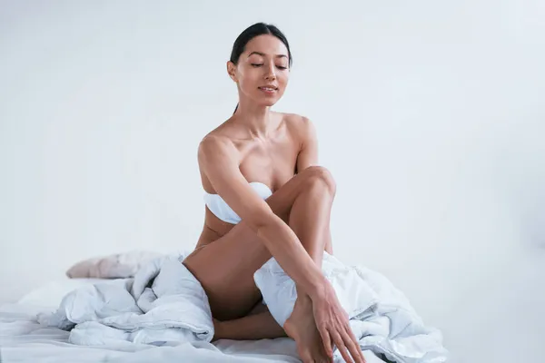Çamaşırlı Vücudu Güzel Genç Bir Kadın Stüdyoda Beyaz Arka Planda — Stok fotoğraf