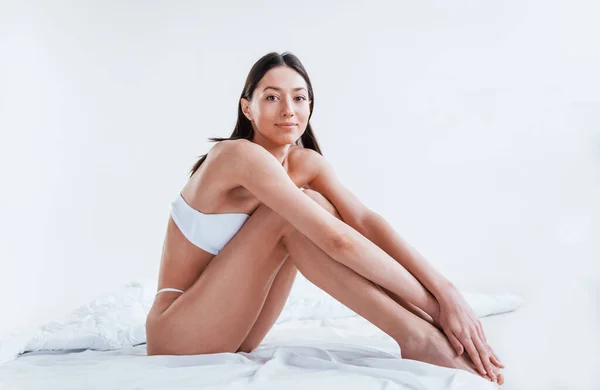 Posing on the white cube. Woman in underwear with slim body type is in the  studio 8366069 Stock Photo at Vecteezy