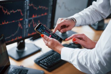 Üzerinde telefon ve grafikler olan insanların ellerinin görüntüsünü kapat. Borsacıların bir işi var..