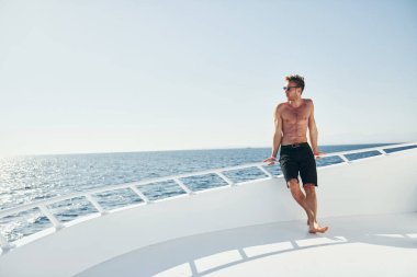 Genç erkek turist denizdeki yatta. Tatil kavramı.