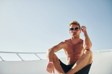 Ilık hava. Genç erkek turist denizdeki yatta. Tatil kavramı.