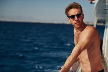 Ilık hava. Genç erkek turist denizdeki yatta. Tatil kavramı.