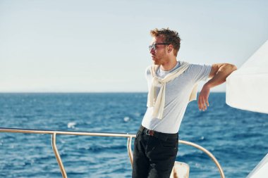Ilık hava. Genç erkek turist denizdeki yatta. Tatil kavramı.