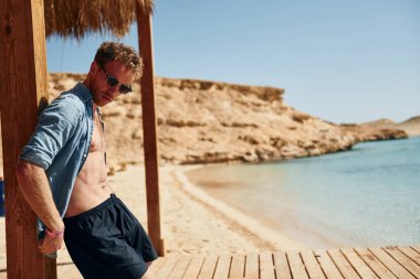 Temiz su. Genç Avrupalı adam tatilde ve deniz kıyısında boş zamanlarının tadını çıkarıyor..