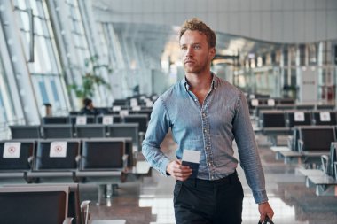 Resmi kıyafetli genç adam modern havaalanında. Tatil kavramı.