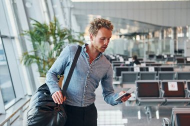 Resmi kıyafetli genç adam modern havaalanında. Tatil kavramı.