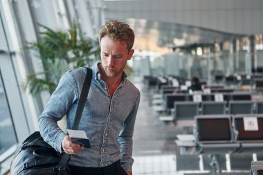 Resmi kıyafetli genç adam modern havaalanında. Tatil kavramı.