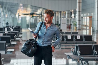 Resmi kıyafetli genç adam modern havaalanında. Tatil kavramı.