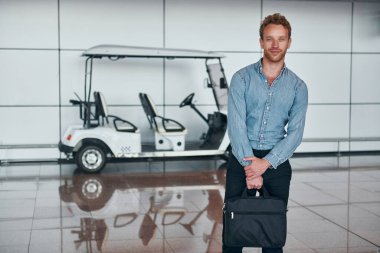 Araca karşı. Resmi kıyafetli genç adam modern havaalanında. Tatil kavramı.