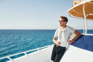 Genç erkek turist denizdeki yatta. Tatil kavramı.