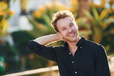 Genç adam güneşli bir günde dışarıda. Tatil kavramı.