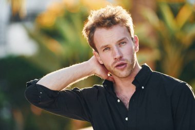 Genç adam güneşli bir günde dışarıda. Tatil kavramı.