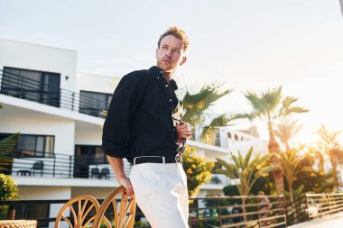 Genç adam güneşli bir günde dışarıda. Tatil kavramı.