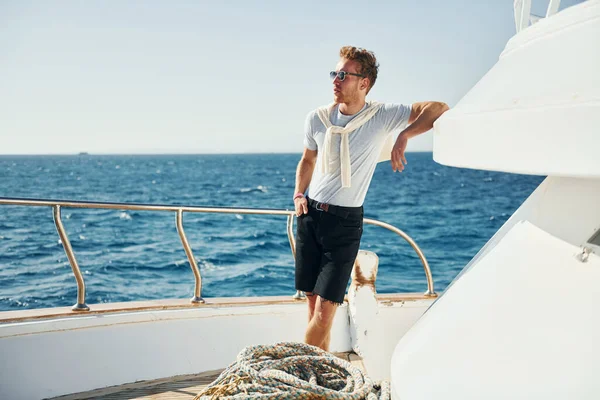 Ilık hava. Genç erkek turist denizdeki yatta. Tatil kavramı.