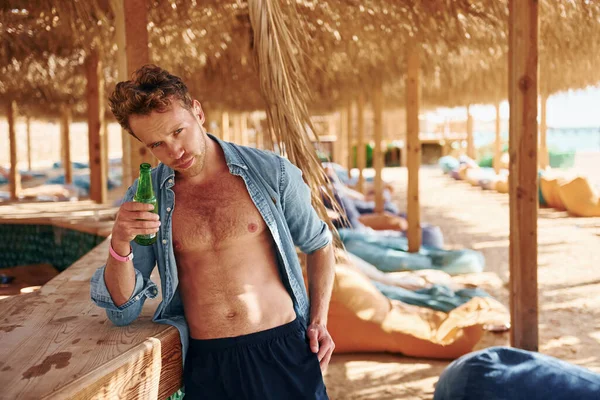 Vücudu gösteriyor. Genç Avrupalı adam tatilde ve deniz kıyısında boş zamanlarının tadını çıkarıyor..