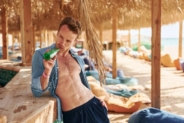 Vücudu gösteriyor. Genç Avrupalı adam tatilde ve deniz kıyısında boş zamanlarının tadını çıkarıyor..