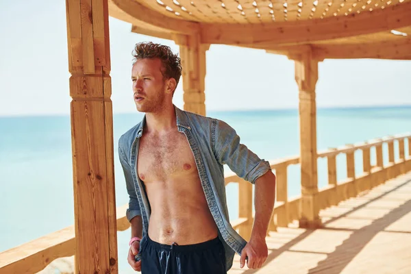 木造建築 若いヨーロッパの男は休暇を持っており 海のビーチで自由な時間を楽しんでいます — ストック写真