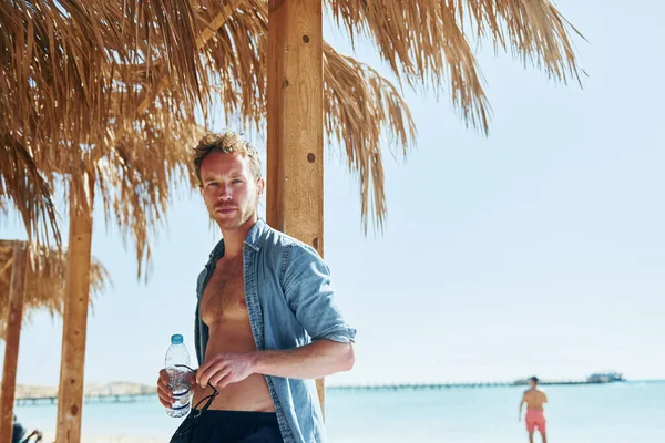カメラのためにポーズ 若いヨーロッパの男は休暇を持っており 海のビーチで自由な時間を楽しんでいます — ストック写真