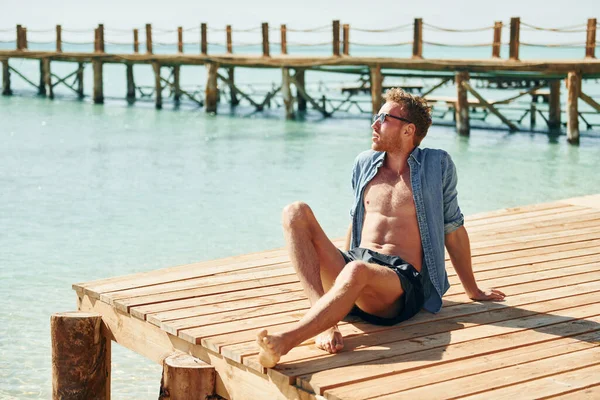 Temiz su. Genç Avrupalı adam tatilde ve deniz kıyısında boş zamanlarının tadını çıkarıyor..
