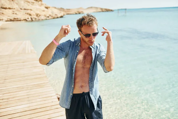 サングラス 若いヨーロッパの男は休暇を持っており 海のビーチで自由な時間を楽しんでいます — ストック写真
