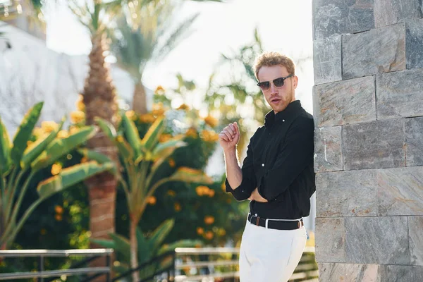 Güneş gözlüklü. Genç adam güneşli bir günde dışarıda. Tatil kavramı.