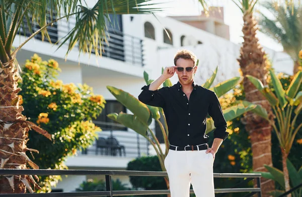 Güneş gözlüklü. Genç adam güneşli bir günde dışarıda. Tatil kavramı.