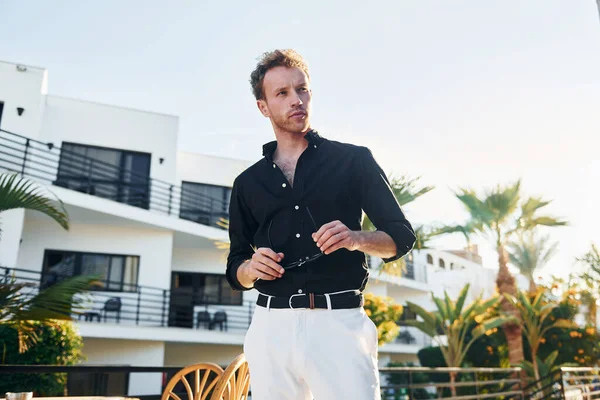 Genç adam güneşli bir günde dışarıda. Tatil kavramı.