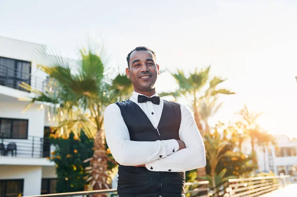 Kamera için poz vermek. Resmi kıyafetli zenci garson güneşli bir günde iş yerinde..