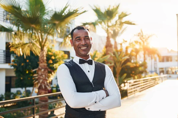 Kamera için poz vermek. Resmi kıyafetli zenci garson güneşli bir günde iş yerinde..