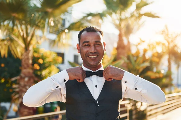 Kamera için poz vermek. Resmi kıyafetli zenci garson güneşli bir günde iş yerinde..