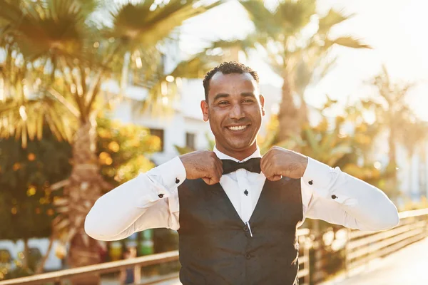 Kamera için poz vermek. Resmi kıyafetli zenci garson güneşli bir günde iş yerinde..