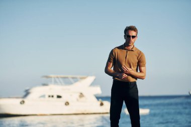 Güneş gözlüklü. Genç adam güneşli bir günde dışarıda. Tatil kavramı.