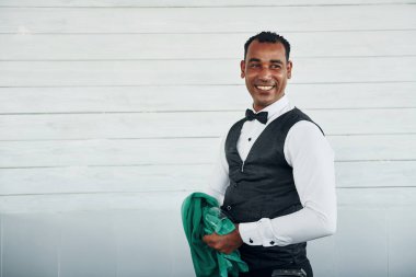 Resmi kıyafetli zenci garson güneşli bir günde iş yerinde..