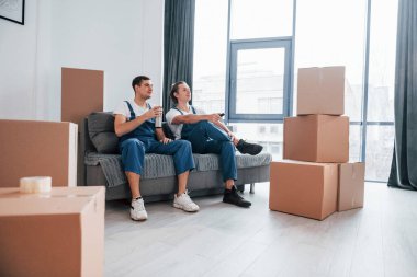 İçeride çalışan mavi üniformalı iki genç nakliyeci..