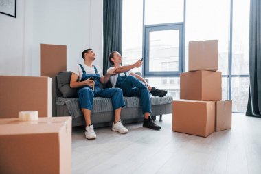 İçeride çalışan mavi üniformalı iki genç nakliyeci..