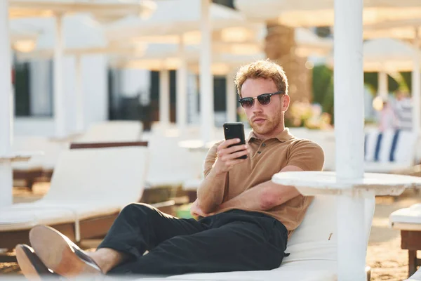 Sits Uses Phone Young Man Outdoors Sunny Daytime Concept Vacation — Stockfoto