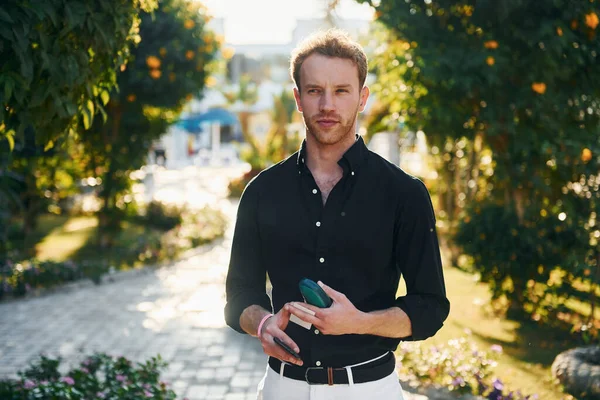 Genç adam güneşli bir günde dışarıda. Tatil kavramı.