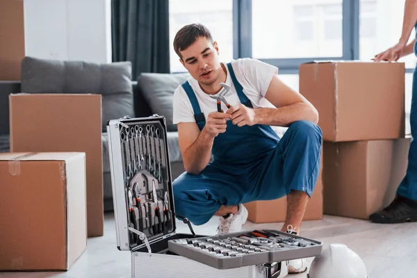 Mavi üniformalı genç adam içeride çalışıyor..