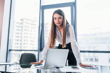 Beyaz elbiseli genç kadın modern ofiste kapalı bir yerde..