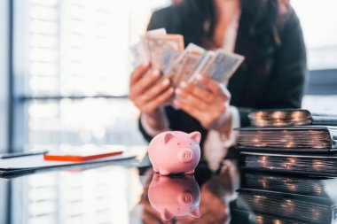 Para birimiyle. Siyah elbiseli kadın modern ofiste kapalı bir yerde..