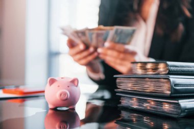 Para birimiyle. Siyah elbiseli kadın modern ofiste kapalı bir yerde..